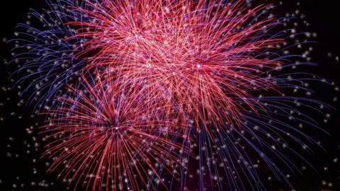 Reuters Red and purple fireworks explode