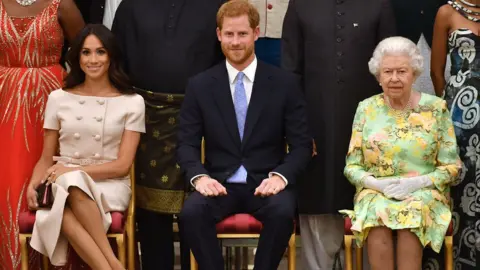 Getty Images Meghan, Duchess of Sussex, Britain's Prince Harry, Duke of Sussex and Britain's Queen Elizabeth II pose for a picture during the Queen's Young Leaders Awards Ceremony on June 26, 2018