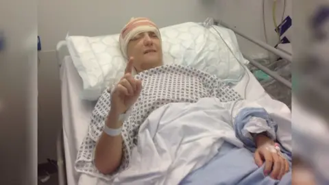 Rachel Bown Ms Bown laying in a hospital bed with a bandage over her eye