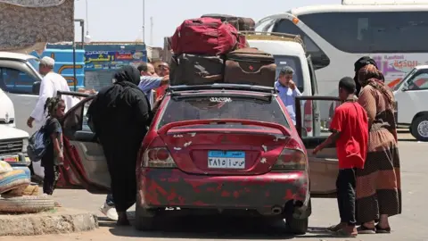 EPA-EFE/REX/Shutterstock People fleeing Sudan arrive at Wadi Karkar bus station in Aswan, southern Egypt