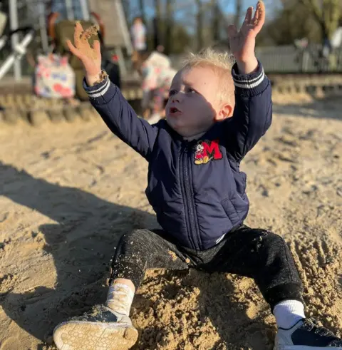 Family photo Harry Jackson playing in the sand in a playground