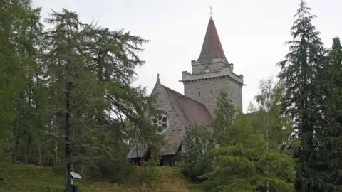 The PA Media Church building with red tiled roof is located between trees