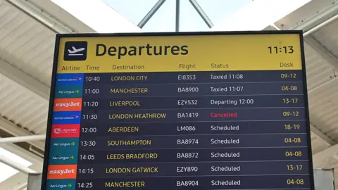 A departures board which shows around a dozen flights including one to London Heathrow which is marked as "Cancelled"