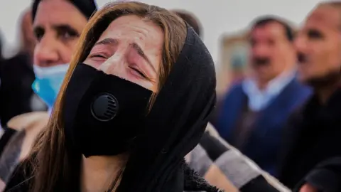 Getty Images Woman reacts during the mass funeral in Kocho on 6 February 2021