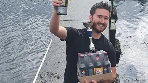 Boris Kitching Men's race winner David Watts holding a trophy and prize
