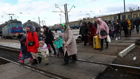 Reuters/ KAI PFAFFENBACH Refugees at the train station in Lviv, Ukraine