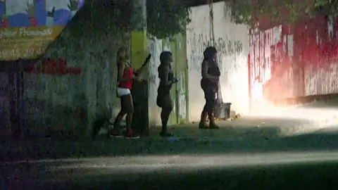 BBC Women on a dark street in Haiti