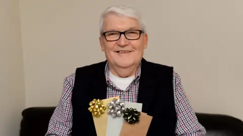 Wales news service Keith Cass holding three envelopes