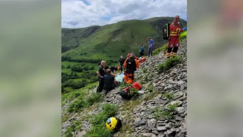 Aberdyfi Search & Rescue Team rescuers saving biker on hillside