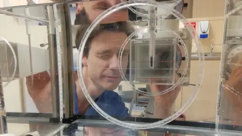 Mark Long Mark Long looking through laboratory equipment