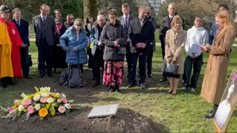 Clare Mulley Crowd gathers around the grave