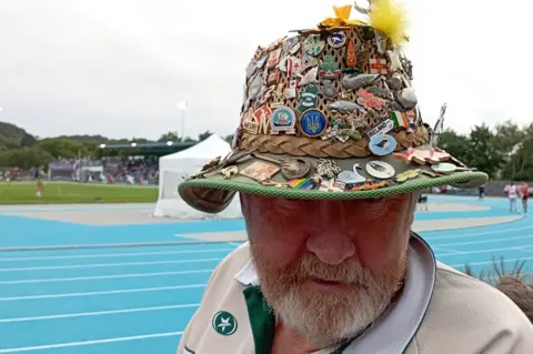 Guernsey2023 Man with hat full of pin badges
