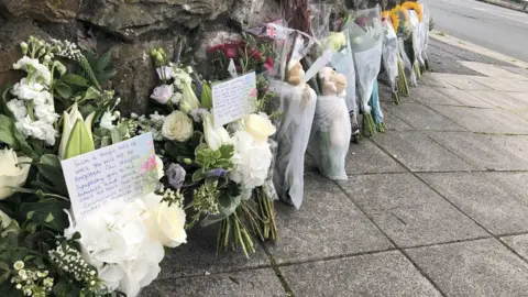 PA Media Floral and soft toy tributes were left on Wolesley Road, near Biddick Drive