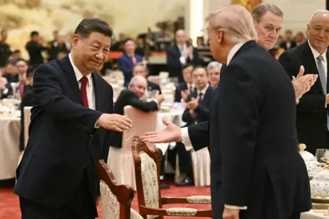 AFP via Getty Images China's President Xi Jinping (L) shakes hands with US President Donald Trump at a state banquet at the Great Hall of the People in Beijing on May 14, 2026. 