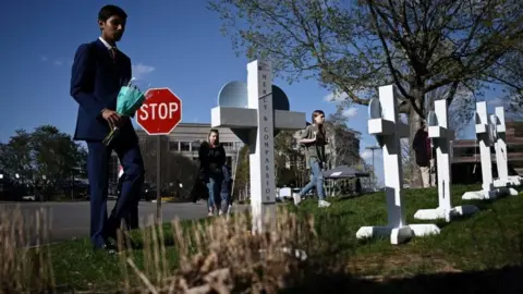 Getty Images A boy leaving flowers at a makeshift memorial on Tuesday