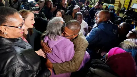 AFP Alfred chestnut hugs his mother surrounded by a crowd