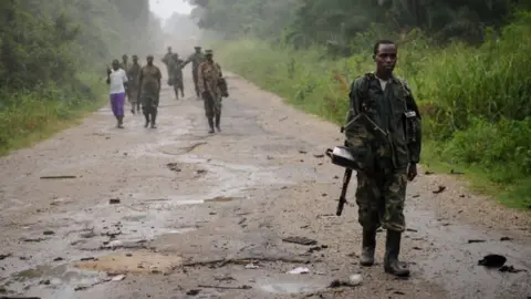 Getty Images This picture taken on July 28, 2012 shows M23 rebels walking along a road through jungle in the Virunga National Park, near the village of Mabenga in the Democratic Republic of the Congo's restive North Kivu province