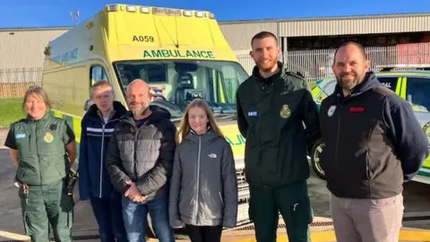 BBC People standing near an ambulance