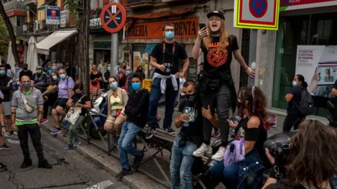 Getty Images A woman speaks to other protesters wearing protective masks during a demonstration, in the Vallecas area