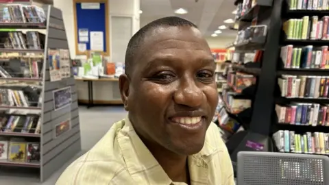 Dr Solomon Lebese smiling in a library