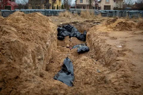 A mass grave on the grounds of a church in Bucha, where bodies were discovered when the Russians retreated