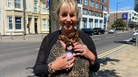 Sue Robson holds a doll
