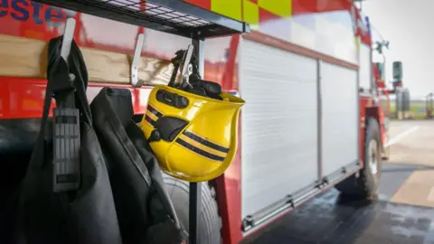 Getty Images A firefighter's helmet is hung up on a fire engine. 