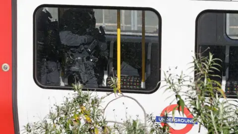 DANIEL LEAL-OLIVAS Armed police walk through an underground train