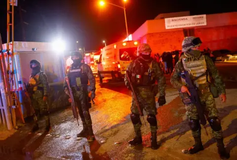 Reuters Soldiers keep watch at the entrance of a migrant detention centre, after a fire broke out leaving several casualties, in Ciudad Juarez, Mexico March 27, 2023.