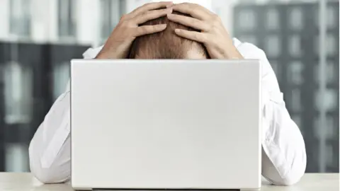 Getty Images Person looking stressed at computer