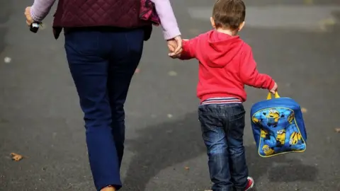 PA Woman and child walking to nursery
