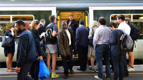 Getty Images Commuters getting on a train