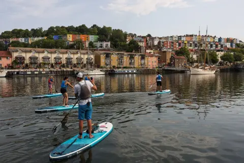 Tom Wren / SWNS Paddle boarders in Bristol