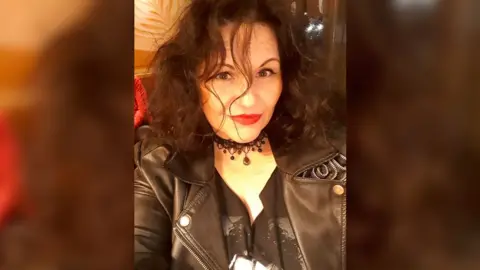 Contributor image Sarah, a woman with dark hair wearing a black jacket