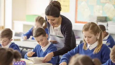 Getty Images Teacher in classroom with pupils