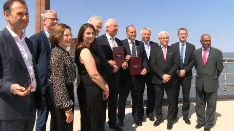 BBC Ministers standing in front of the Grimsby dock tower