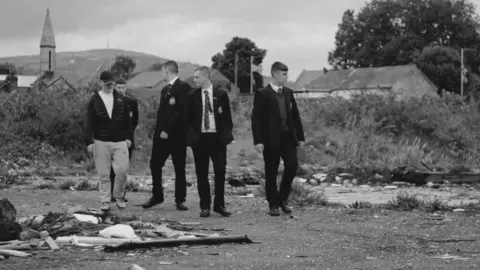 Open University School boys in field with rubbish scattered