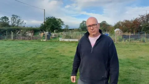 David Plummer Photo of Mr Plummer standing in front of land at centre of dispute
