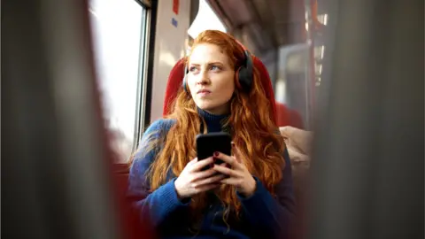 Getty Images Woman looking concerned on train