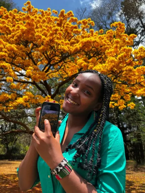 Reuters Elizabeth Wathuti, Kenyan environment and climate activist displays a photograph she took after a Reuters interview at the Nairobi Arboretum, botanical garden, in Nairobi, Kenya October 8, 2022.