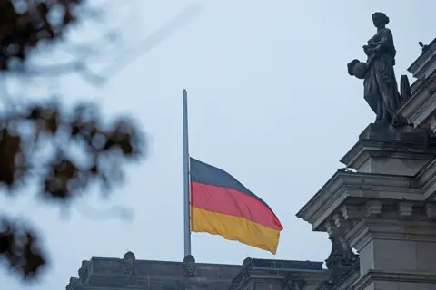 Michelle Tantussi / Reuters The German national flag flies at half mast outside the Bundestag on 27 January 2023