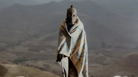 AFP A man wrapped in a traditional Lesotho blanket posing for a portrait as he gathers with residents of communities around the Katse Dam