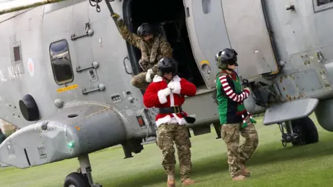 RNAS Culdrose Royal Navy observer Lt Aren Tingle and Lt Emma Turner leave helicopter after landing to greet the schoolchildren