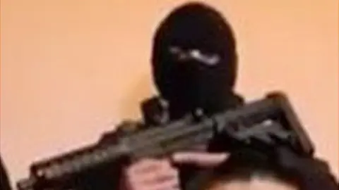 YouTube A screen grab of the video showing one of the armed men