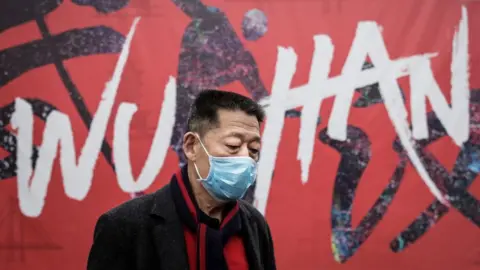 Getty Images A man wears a mask while walking in the street on January 22, 2020 in Wuhan, Hubei province, China.