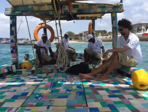 Munira Hussein/BBC People sit on board the Flip-flop Dhow