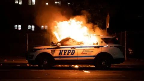 Reuters A NYPD police car is set on fire as protesters clash with police during a march against the death in Minneapolis police custody of George Floyd, in the Brooklyn borough of New York City, U.S., May 30, 2020