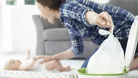 Getty Images Mother changing her baby