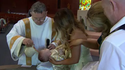 Rev McElmeel baptising a baby