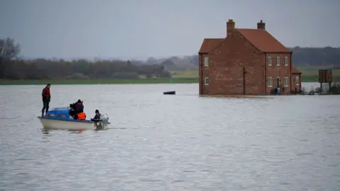 Christopher Furlong/Getty Images Mr Ward on a boat after his farm flooded in 2019